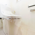 白を基調とした空間に設置されたトイレ。温水洗浄便座のついたものを新規に交換。
