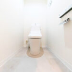 白を基調とした清潔感ある空間にあるトイレ。便座などは交換を行い温水洗浄便座があるものに交換。