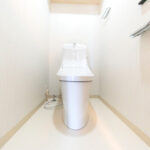 白を基調とした清潔感のある空間に設置されたトイレ。温水洗浄便座に交換しさらに清潔感をました。(内装)