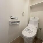 ホワイトを基調とした明るく清潔感のある空間に設置されたトイレ。今回のリフォームで温水洗浄便座が付いたものに新規交換。(内装)